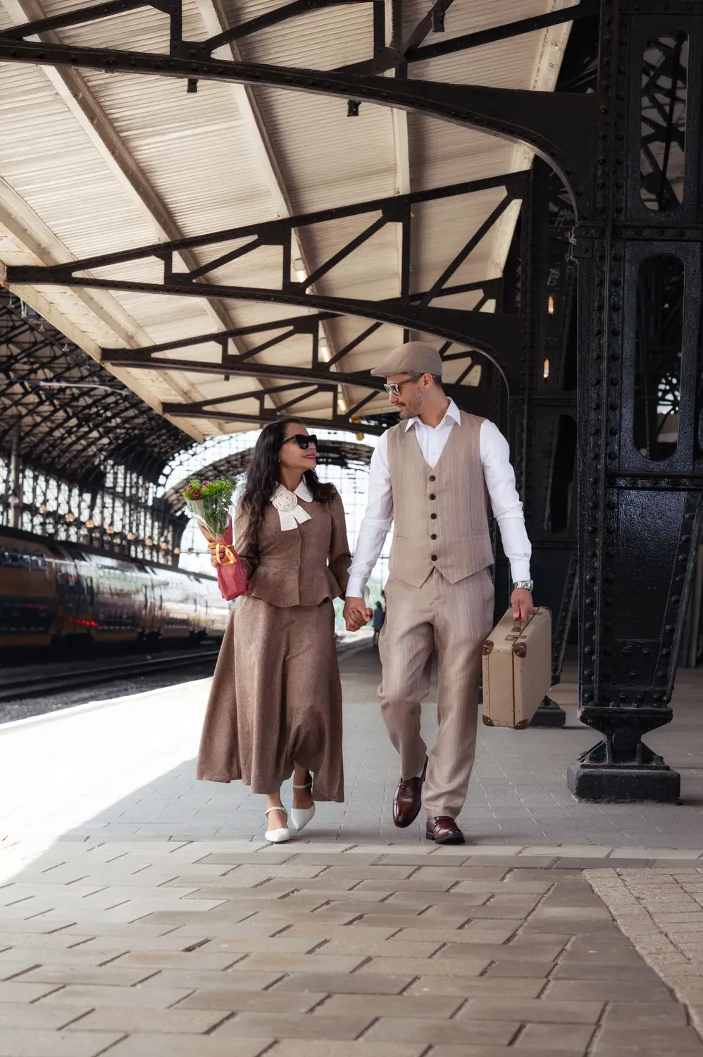 Casal caminhando sob as arcadas de ferro da estação