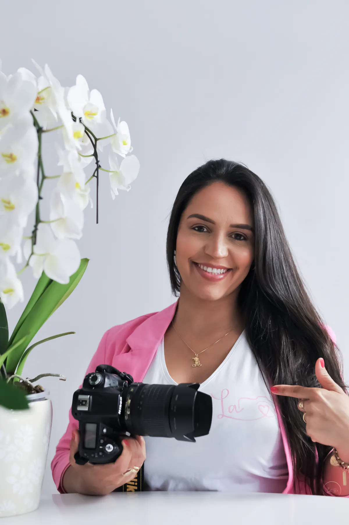 Lidiane Almeida segurando sua câmera, em ambiente claro